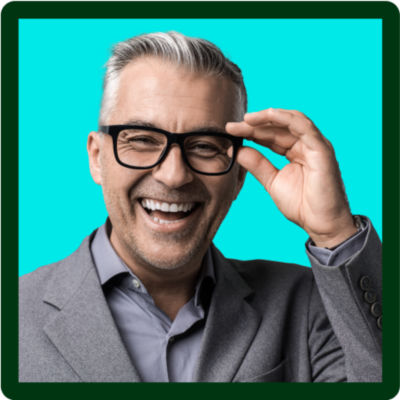 A man in a suit smiling touching his glasses