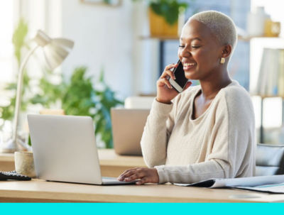 woman working on laptop talking on phone applying for business financing