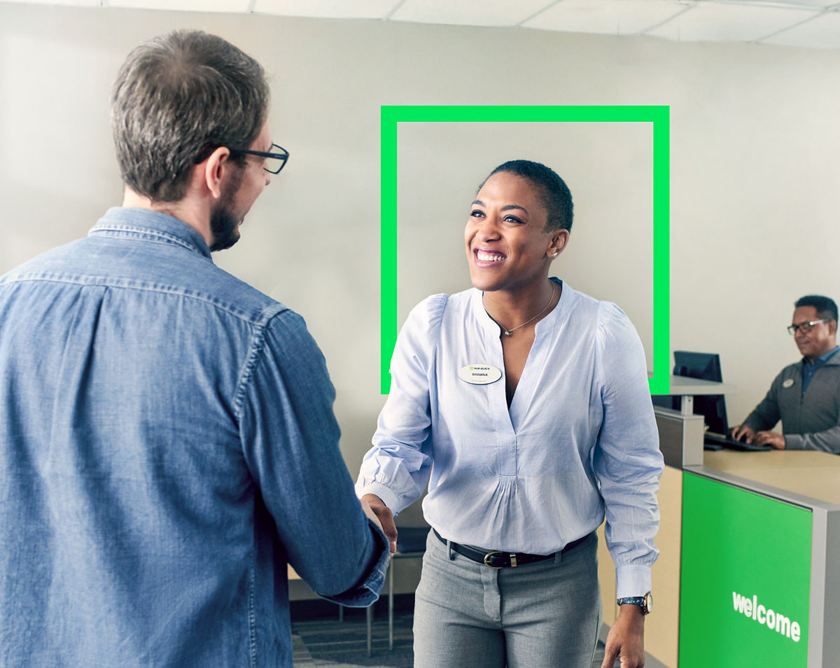 female tax pro greeting male client in tax office