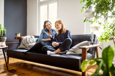 woman showing her friend how H&R block tax filing works