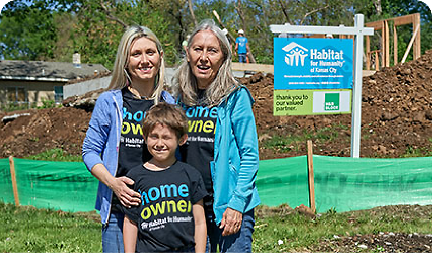 family in front of Habitat for Humanity sign