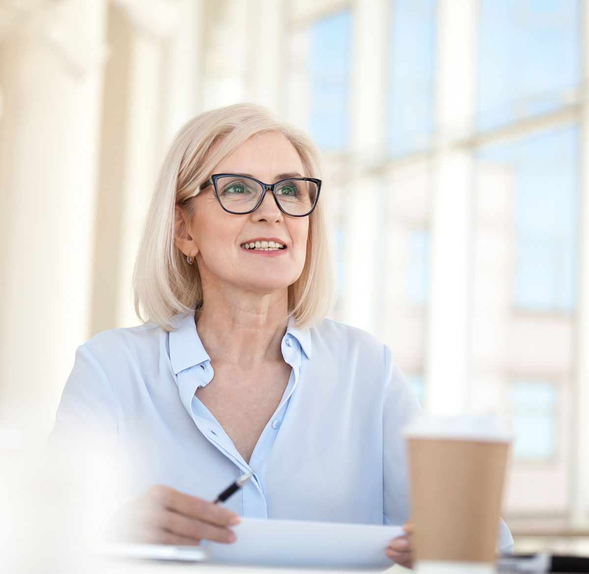 woman reviewing papers while drinking coffee