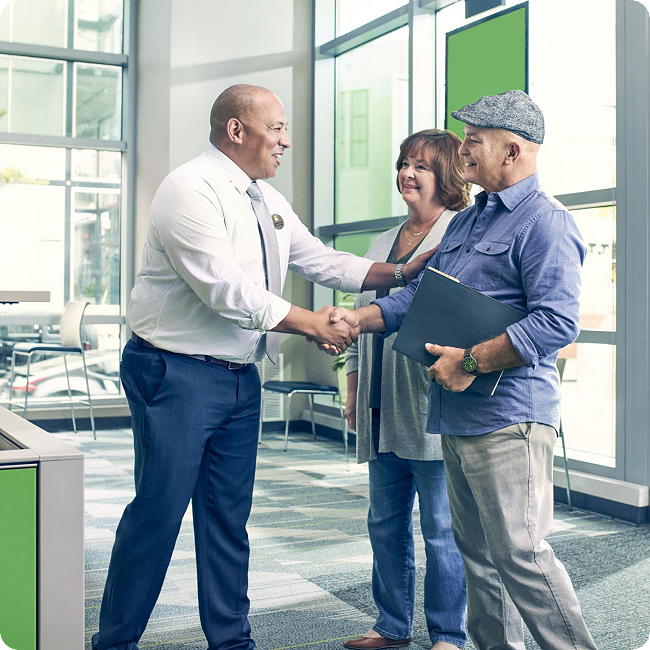 tax pro greeting man and woman in H&R Block tax office