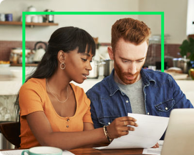 A couple filing taxes in a kitchen